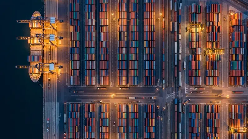 Aerial view of a container yard with stacks of containers and chassis